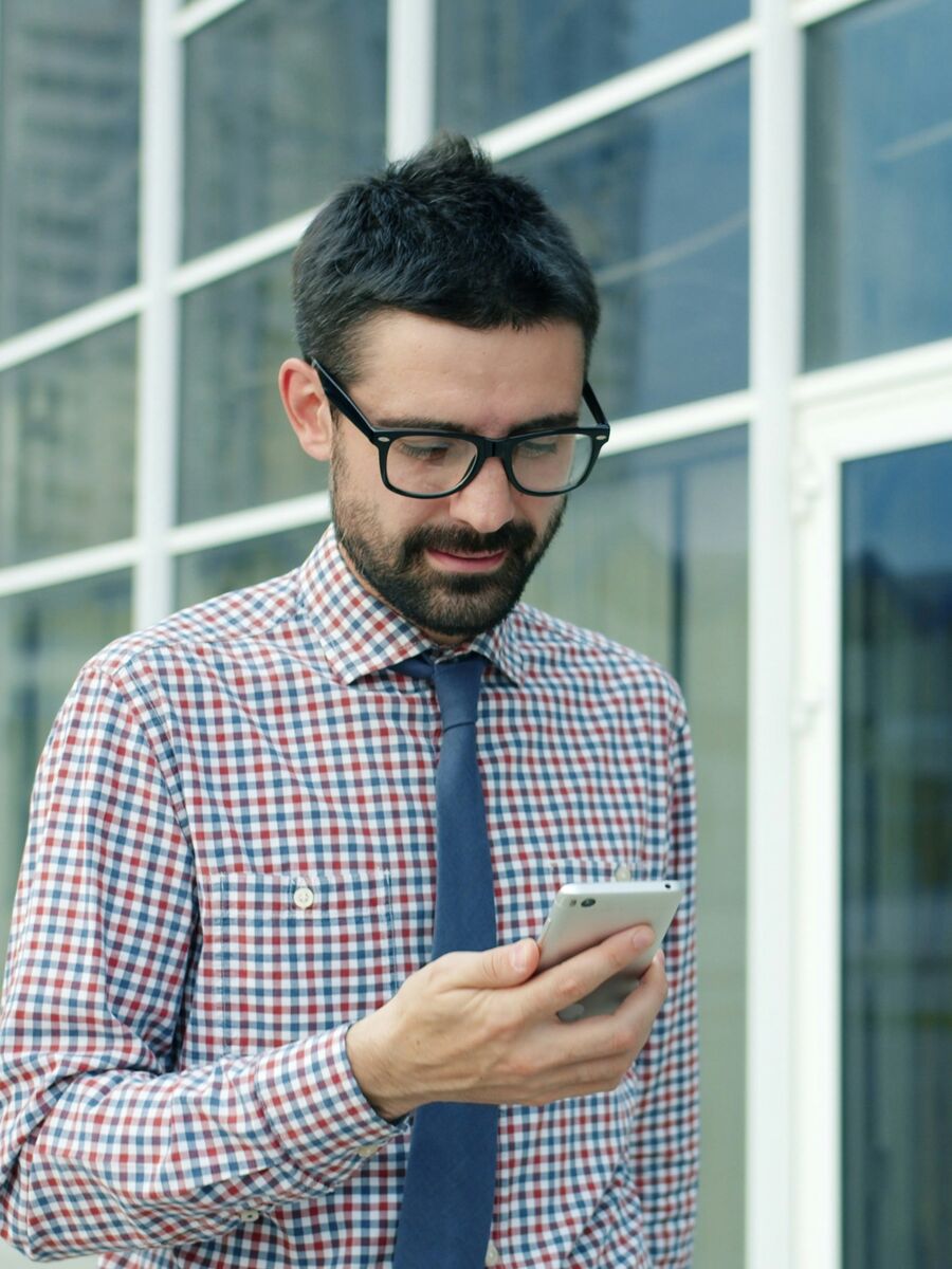 Vendedor revisando el teléfono en la calle